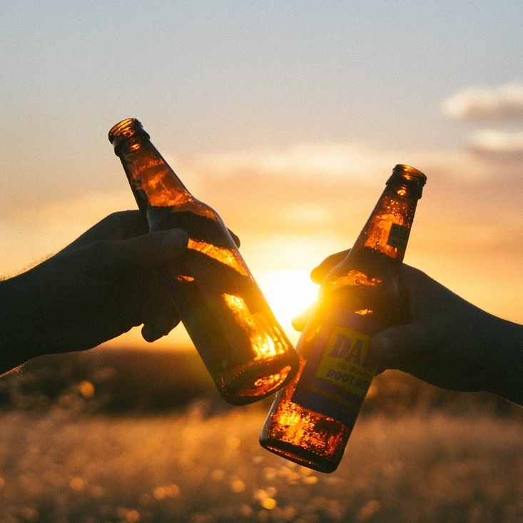 Prost: Zwei anstoßende Bierflaschen.