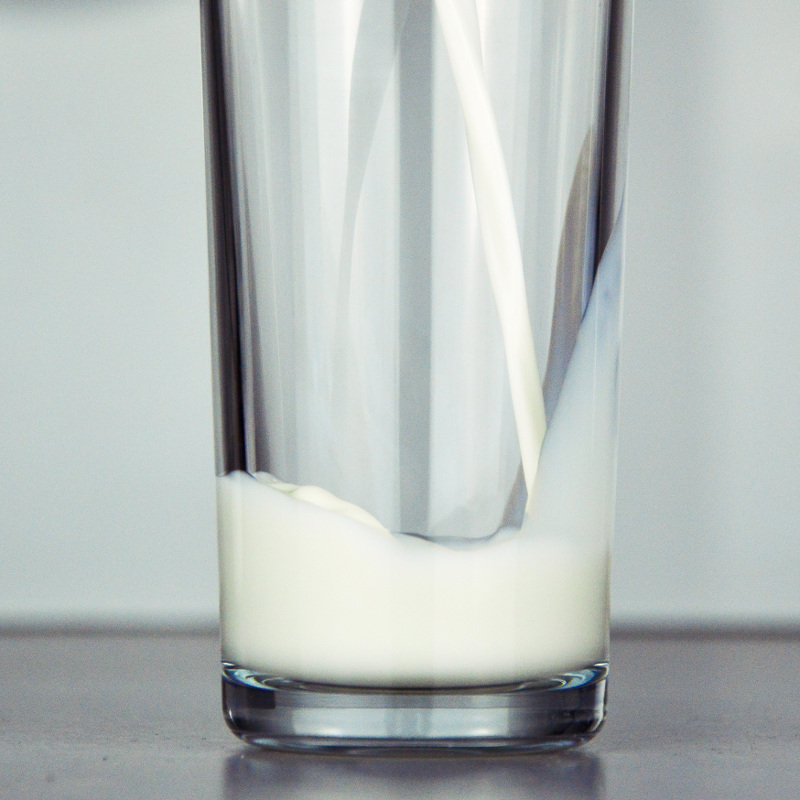 Milch wird in ein Glas gegossen