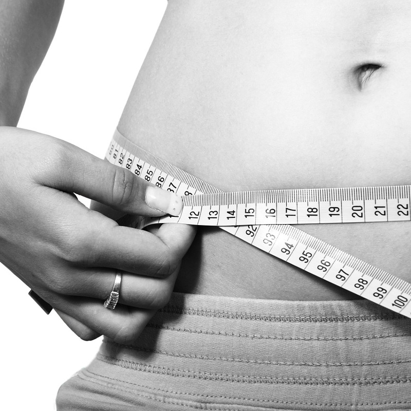 Mit Millimetermaß wird ein Bauch vermessen (schwarz/weiß)