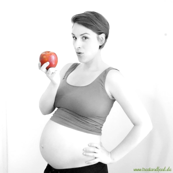 Gesunde Ernährung in der Schwangerschaft: Schwangere Frau mit einem Apfel in der Hand
